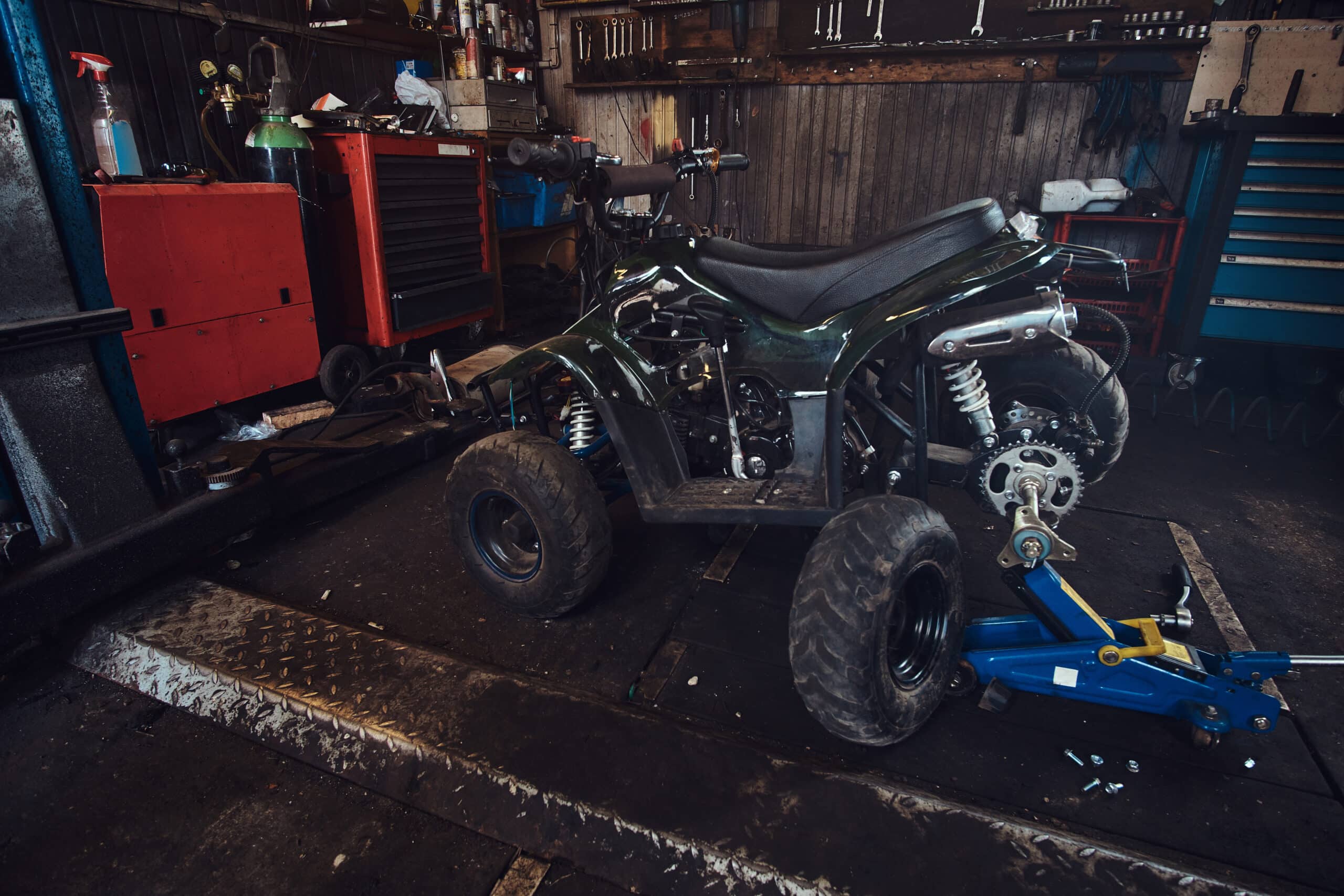 ATV with broken wheel at auto service workshop is waiting to be fixed